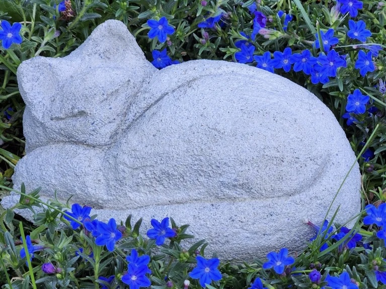 Concrete cat sculpture by Katherine Sallas among blue flowers